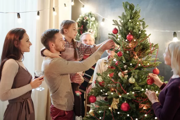 Familie schmückt einen Weihnachtsbaum.