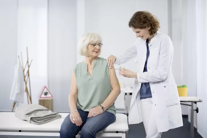 Ältere Frau lässt sich von der Ärztin impfen.