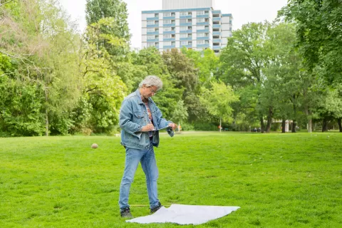 Mann schreibt auf Klemmbrett im Stadtpark